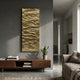 Illume Gold II Hand-Painted Wood Relief 3D Wall Art by Giant Sculptures, a tall crumpled gold panel on a grey wall above a walnut console with snake plant.