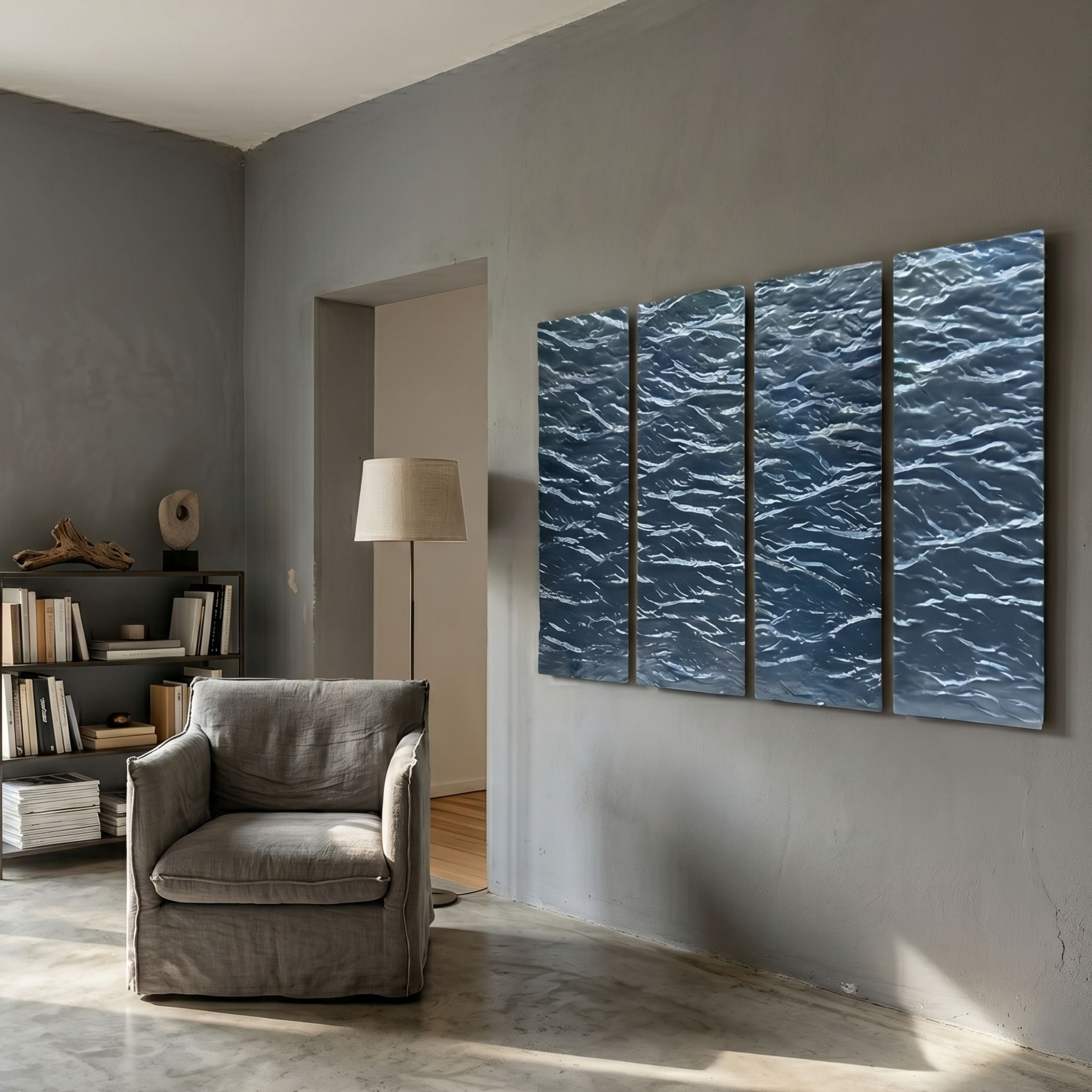 Illume 4-Panel Blue Hand-Painted Wood Relief 3D Wall Art by Giant Sculptures displayed on a grey wall above a linen armchair, floor lamp, and low bookshelf.