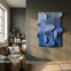 Mystique Blue Fabric Abstract Wood Relief 3D Wall Art by Giant Sculptures, a triptych of wavy blue gradient panels mounted above a leather sofa and bookshelf.