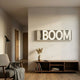 Aurova I Industrial Glow 3D LED Wall Art by Giant Sculptures, illuminated BOOM lettering on grey slatted panel above a walnut console in a modern living room.