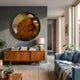 Genesis Sunburst 3D Resin Crystal Porcelain LED Wall Art by Giant Sculptures mounted on a charcoal feature wall above a teak sideboard in a modern living room.