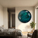 Genesis Midnight 3D Resin Crystal Porcelain LED Wall Art in teal and turquoise, mounted above a bed in a bedroom with grey linens and a potted plant nearby.