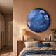Genesis Ocean 3D Resin Crystal Porcelain LED Wall Art by Giant Sculptures, round blue and white cloud design displayed above a walnut headboard in a warm bedroom.