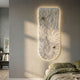 Blossom Serenity White Leather 3D LED Wall Art with layered feather-like petals and seashell accents, backlit on a grey bedroom wall beside an olive bed.