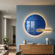 Lumea Sapphire 3D LED Crystal Porcelain Wall Art with a round sapphire-blue disc, gold bar, and halo backlight mounted above an oak sideboard.