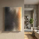 Wavluxe Gradient Sunset Hues Wood Mosaic 3D Wall Art mounted on a cream wall, with black-to-yellow slats beside a living room with sofa and bookshelf.