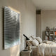 Wavluxe Gradient Silver Wood Mosaic 3D Wall Art mounted in a neutral bedroom above a concrete side table, beside a linen bed and book-filled shelving.