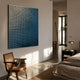 Reflexion Blue Gradient Cube Mosaic 3D Wooden Wall Art by Giant Sculptures mounted in a sunlit bedroom above a cane chair, beside a dark nightstand and bed.