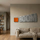 Illustra Vibrant Orange Highlight BOOM Text 3D Wooden Wall Art by Giant Sculptures mounted with an orange square piece above a linen sofa in a modern living room.