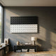 Contrasto Black & White Linear 3D Wooden Wall Art by Giant Sculptures mounted on a grey wall above a console table with a lamp, vases, and books.