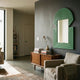 Aurellis Green Arch & Square Geometric Mirror Frame Wall Art by Giant Sculptures mounted on a dark grey wall above a mid-century walnut sideboard in a living room.