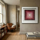 Viretta Red Gradient Pyramid Textured 3D Wooden Wall Art by Giant Sculptures framed in white on a beige wall above a leather armchair and bookshelf.