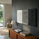 Contrasto Monochrome Symmetry 3D Wooden Wall Art by Giant Sculptures, a triptych of light grey, mid grey and charcoal panels with white pegs, above a teak sideboard.