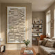 Forma Cream Geometric 3D Wooden Vertical Wall Art in a gold frame, displayed in a neutral living room beside a bookshelf, linen sofa, and wooden coffee table.