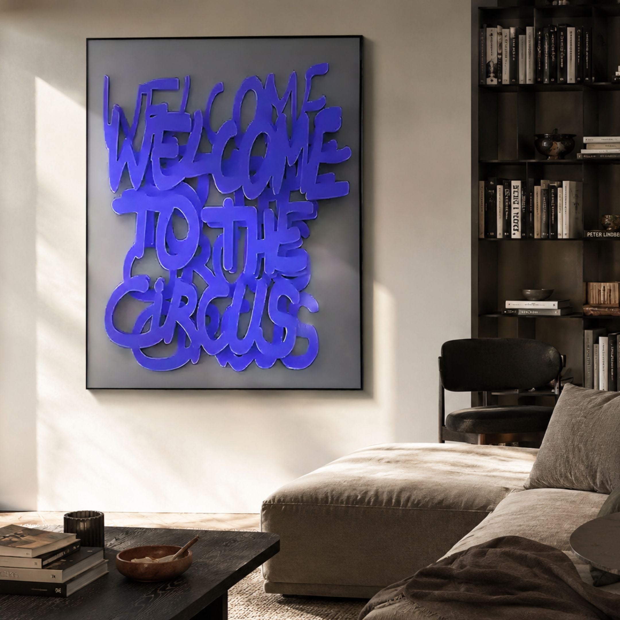 Urbanic Blue Welcome Script 3D Wooden Graffiti Wall Art by Giant Sculptures displayed in a modern living room beside a dark bookshelf, sofa, and chair.