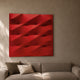 Verto Bold Red Stretch Fabric Layered Wooden 3D Wall Art with diagonal ridges displayed above a beige sofa with neutral cushions in a warm living room.