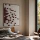 Fragmenta Red Wooden Cube Scatter 3D Wall Art by Giant Sculptures mounted above a wooden bed in a sunlit modern bedroom with a leather chair nearby.