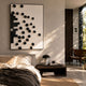 Fragmenta 3D Wall Art by Giant Sculptures with scattered black wooden cubes on white canvas, displayed above a bed with a dark nightstand in a sunlit bedroom.