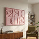 Formate Soft Pink Geometric Wood Painted 3D Wall Art mounted above a walnut sideboard in a Nordic living room with a green armchair and bookshelves.