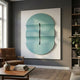 Ellipse Aqua Oval Wood 3D Canvas Wall Art by Giant Sculptures displayed above a leather armchair and wooden coffee table in a modern grey living room.