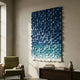 Stratiform Monochrome Mist Gradient Wood Mosaic 3D Wall Art in blue-to-white tones mounted above a wooden console beside a green armchair in a sunlit room.