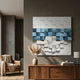 Structura Azure Blue & White 3D Wooden Square Wall Art by Giant Sculptures mounted on a dark wall above a walnut sideboard with pampas grass and a leather armchair.