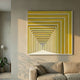 Prismalux Yellow Wood Carving 3D Wall Art by Giant Sculptures with concentric yellow and white frames forming a tunnel illusion, displayed above a beige sofa.