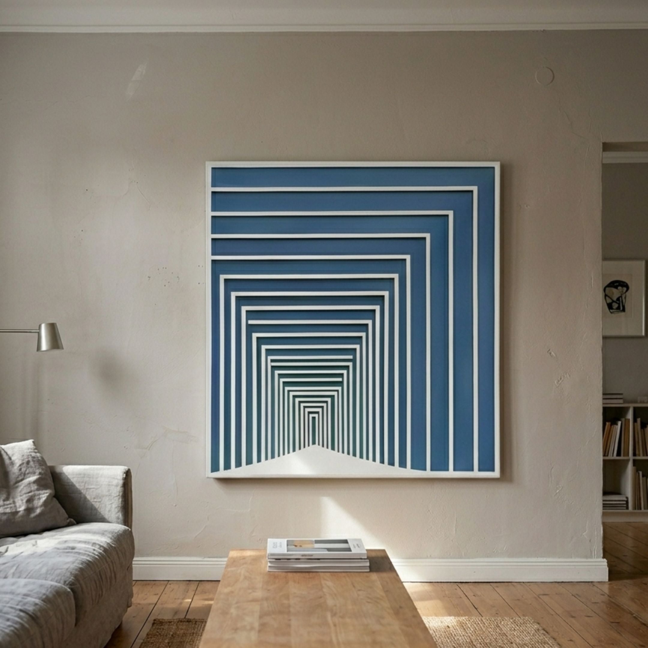 Prismalux Blue Wood Carving 3D Wall Art with concentric blue and white frames creating a tunnel illusion, mounted above a wooden coffee table in a living room.