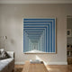 Prismalux Blue Wood Carving 3D Wall Art with concentric blue and white frames creating a tunnel illusion, mounted above a wooden coffee table in a living room.