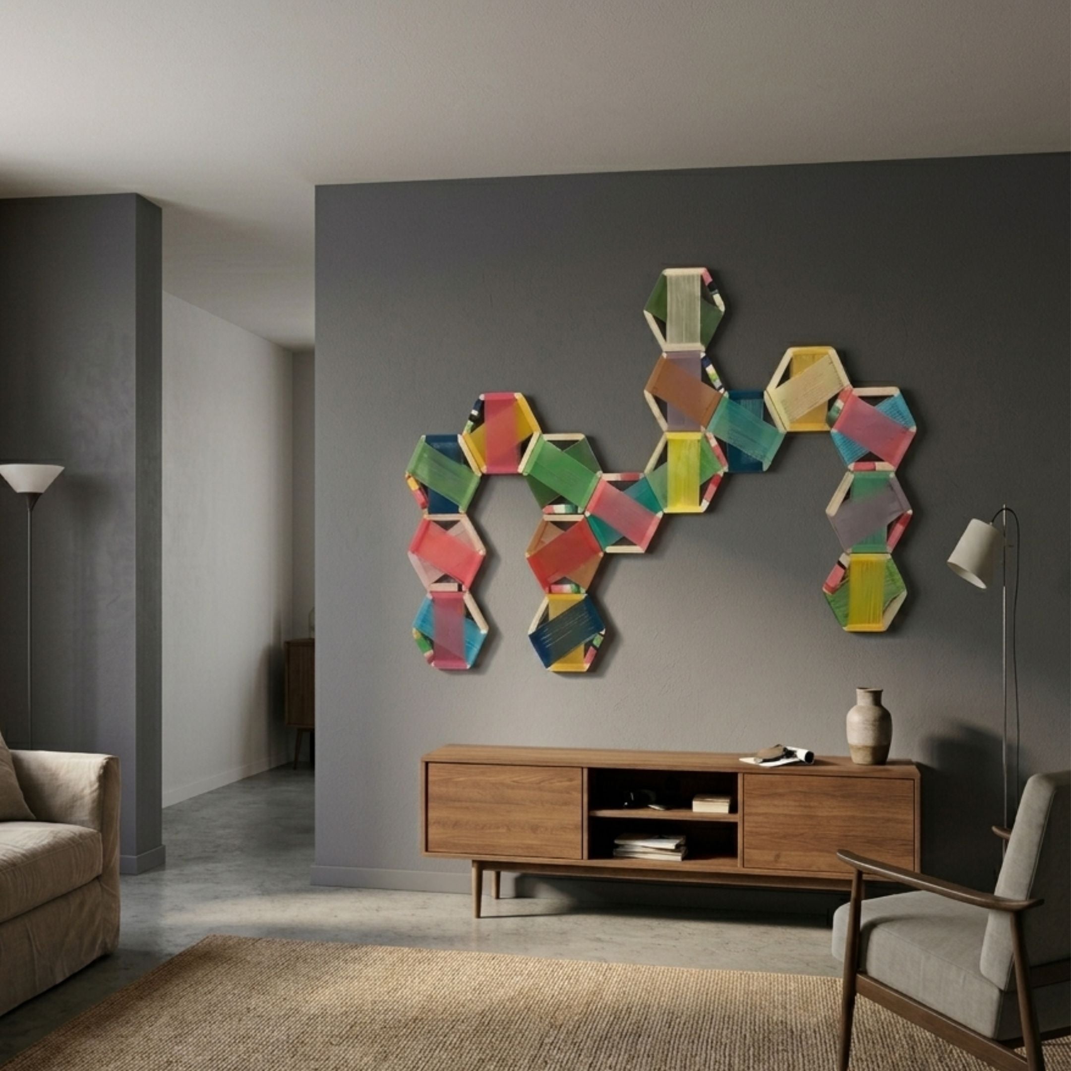 Spectra II Multicoloured Interwoven Hexagonal Frame 3D Wall Art by Giant Sculptures displayed on a grey living room wall above a wooden console with floor lamps.
