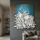 Assemblia Teal Hand-Painted Wood Graffiti Wall Art by Giant Sculptures, white planks and wheels on teal panel, displayed above a grey sofa in a living room.