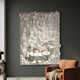 Forme II Cream Wood Cluster Abstract 3D Wall Art by Giant Sculptures mounted on a dark grey living room wall above a tan armchair with throw.