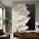 Stratura III Black & White Layered Paper Canvas Wall Art by Giant Sculptures mounted above a walnut console in a modern living room with bookshelves.
