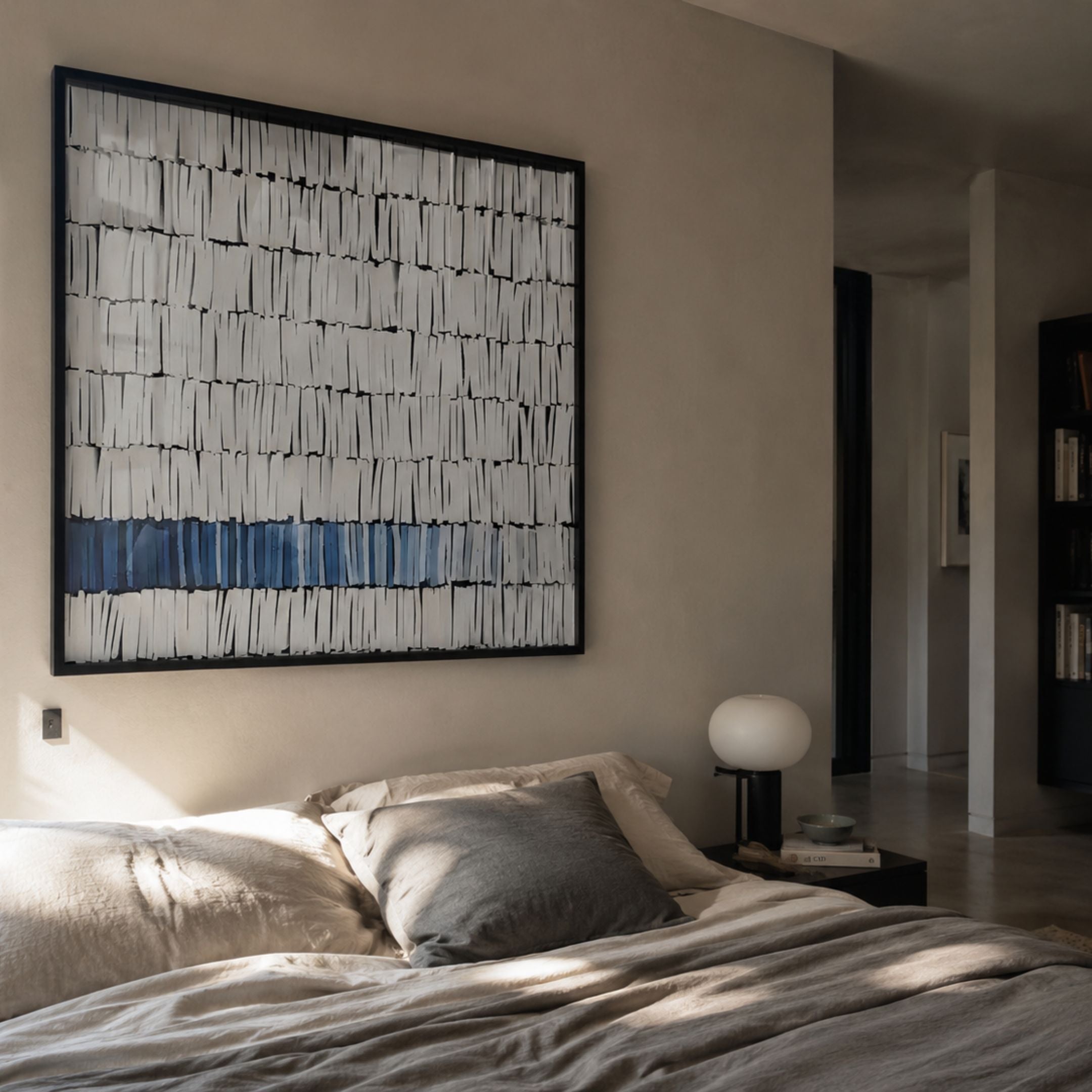 Tracery III Blue & White Textured Paper Wall Art by Giant Sculptures hung above a linen-dressed bed with a globe lamp on a black bedside table.