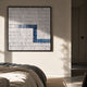Tracery I Blue & White Textured Paper Wall Art by Giant Sculptures in a black frame, hung above a linen-dressed bed in a sunlit minimalist bedroom.
