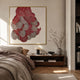 Rosette II Vibrant Red Circular Pattern Wall Art by Giant Sculptures, gold-framed layered semi-circles in red, pink and black, above a wooden bedroom console.