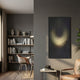 Celeste Radiant Vortex LED Wall Art by Giant Sculptures displayed on a grey wall in a modern living room with a leather chair, side table, and bookshelf nearby.