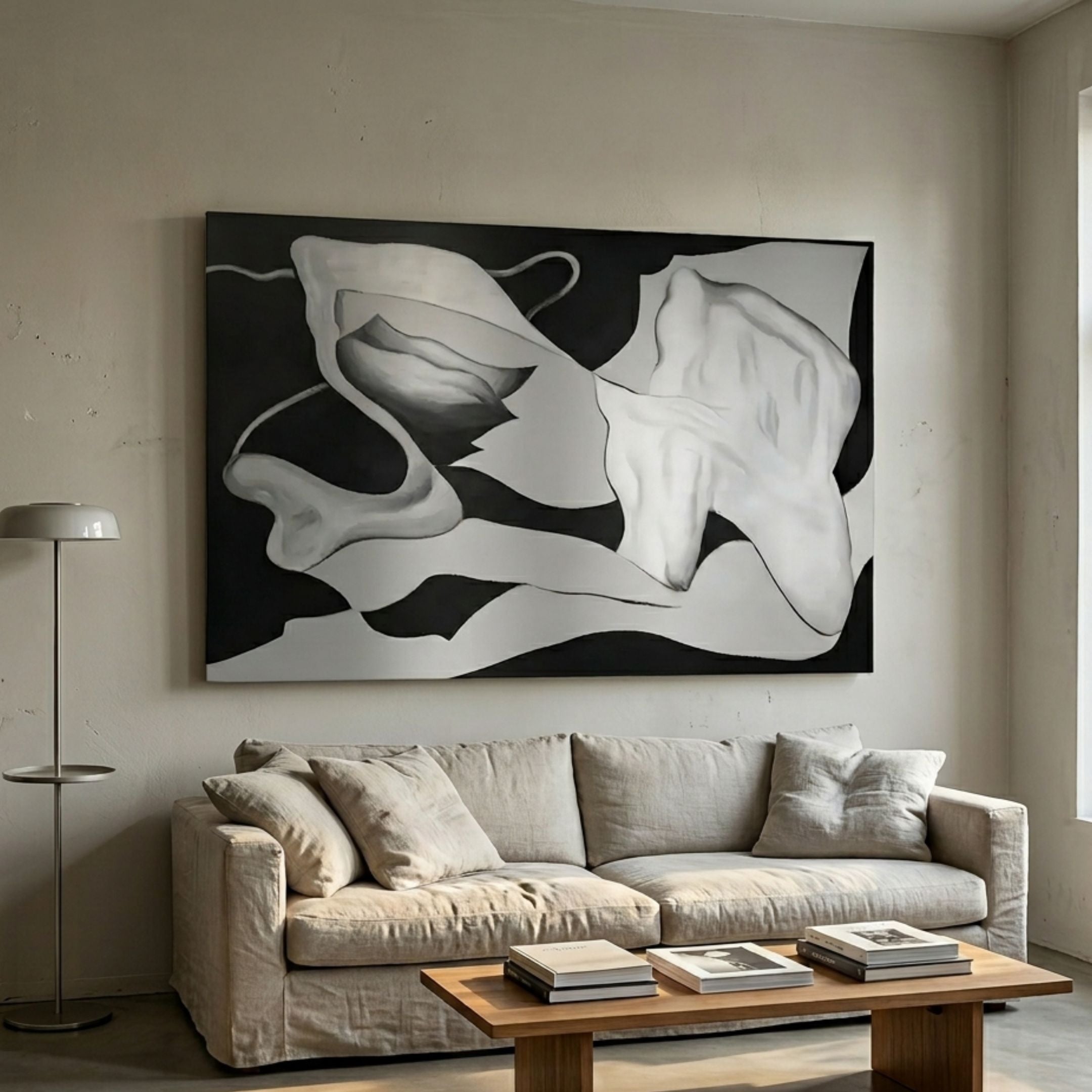 Calmant Black & Silver Abstract Hand-Painted Wall Art by Giant Sculptures hung above a linen sofa in a neutral living room with a floor lamp and wood coffee table.