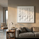 Geometrica Intricate White Fold 3D Wood Relief Wall Art by Giant Sculptures displayed above a grey sofa in a modern living room with a wooden side table.