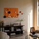 Orbison Terracotta 3D Wood Relief Wall Art with floating navy, white, and orange spheres displayed above a dark wood console in a sunlit living room.