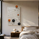 Orbison White 3D Wood Relief Wall Art by Giant Sculptures displayed in a neutral bedroom above a wooden nightstand, with glossy orange, black, and white spheres on a textured white panel.