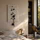 Orbina White 3D Wood Relief Wall Art by Giant Sculptures, mounted in a sunlit bedroom above a nightstand with a mushroom lamp beside a caned chair.