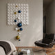 Orbina White 3D Wood Relief Wall Art by Giant Sculptures with blue, gold, and white spheres, displayed in a living room with a leather chair and glass table.