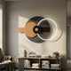 Eclipse II Charcoal Bronze Acrylic 3D LED Wall Art by Giant Sculptures with layered circles and a glowing white arc, mounted above a console with books and vase.