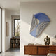 Orison Noir Harmony UV Wood 3D Wall Art by Giant Sculptures with radiating black, blue, and white curved bands, displayed above a teak sideboard in a modern interior.
