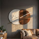 Lunaris White Marble & Bronze LED Wall Art by Giant Sculptures, mounted above a tan leather sofa on a dark grey wall with a wooden console and potted plants.