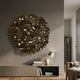 Eclat Sphere Bronze Abstract Metal Wall Art by Giant Sculptures displayed above a grey media console with a table lamp, vase, and books in a modern living room.