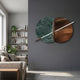 Lunaris Green Marble & Bronze LED Wall Art by Giant Sculptures mounted on a dark grey wall beside a living room bookshelf, sofa, and houseplants.