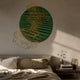 Auramesh Forest Green-II wall art with pleated green leather disc and gold honeycomb mesh wing, mounted above a bed with linen bedding and walnut nightstand.