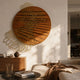 Auramesh Sunset Orange-II Metal Wall Art with pleated bronze disc and gold geometric wings mounted above a wooden console in a warm living room.